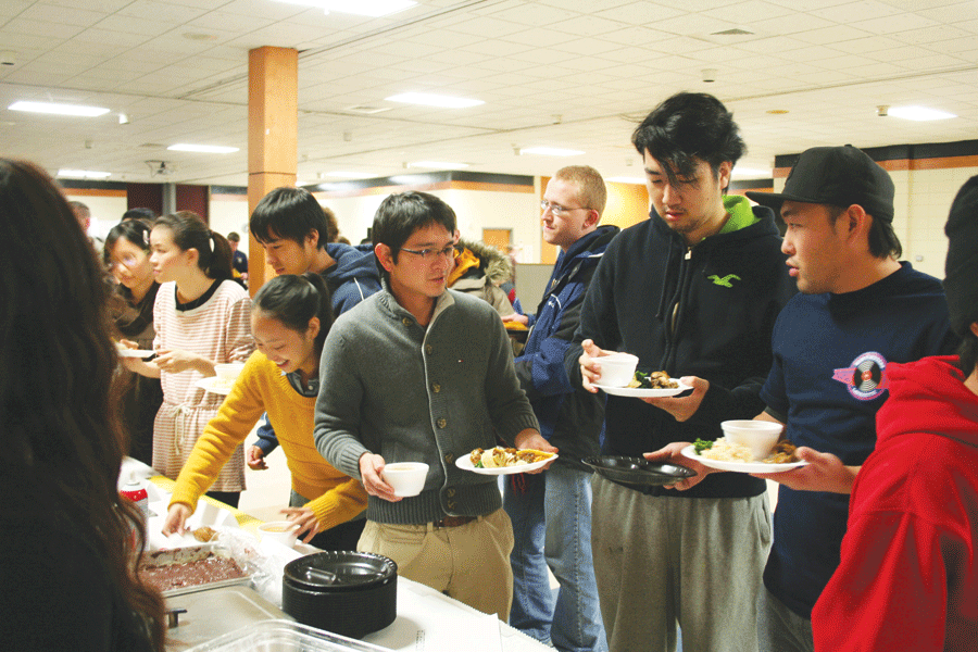 Three students gather round their tasty plates they had been served.  