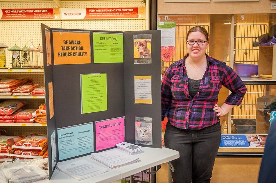 Lindsay Kleckner, senior criminal justice major, stands by her display at the Sheboygan PetSmart during an adoption event with the Sheboygan County Humane Society.