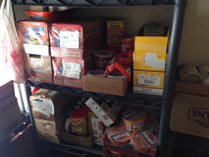 One of two small storage racks in the Muskie Mart storage room, holding ramen and chips.