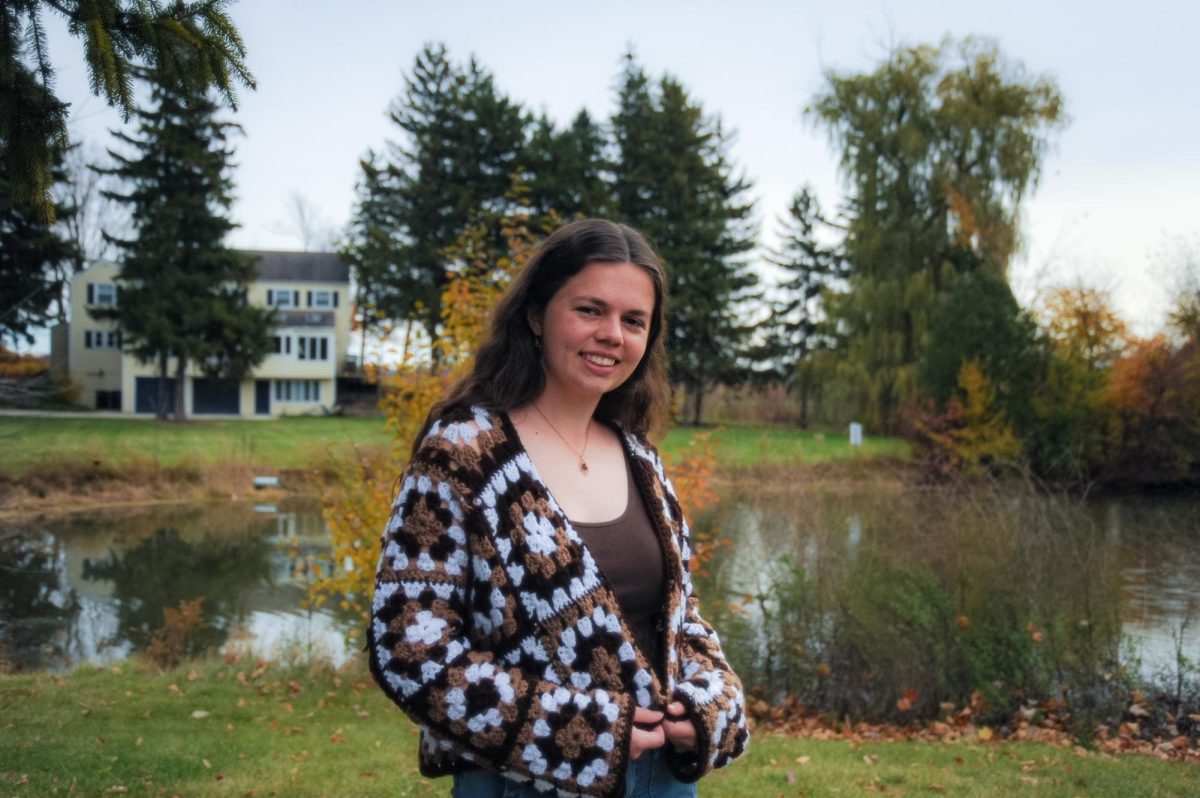 A college student wearing a brown-and-white crocheted granny-square cardigan.